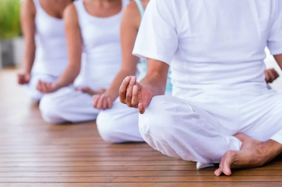 Tres personas comienzan una sesi&oacute;n de yoga y meditaci&oacute;n