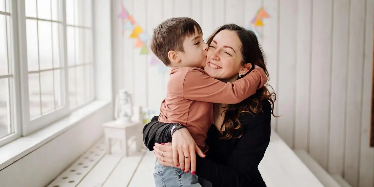 Mother and her son are posing in the studio and wearing casual clothes