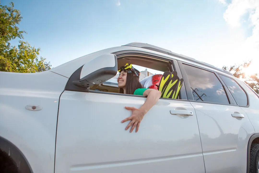 sea car travel trip smiling woman driver in car full of vacation stuff copy space