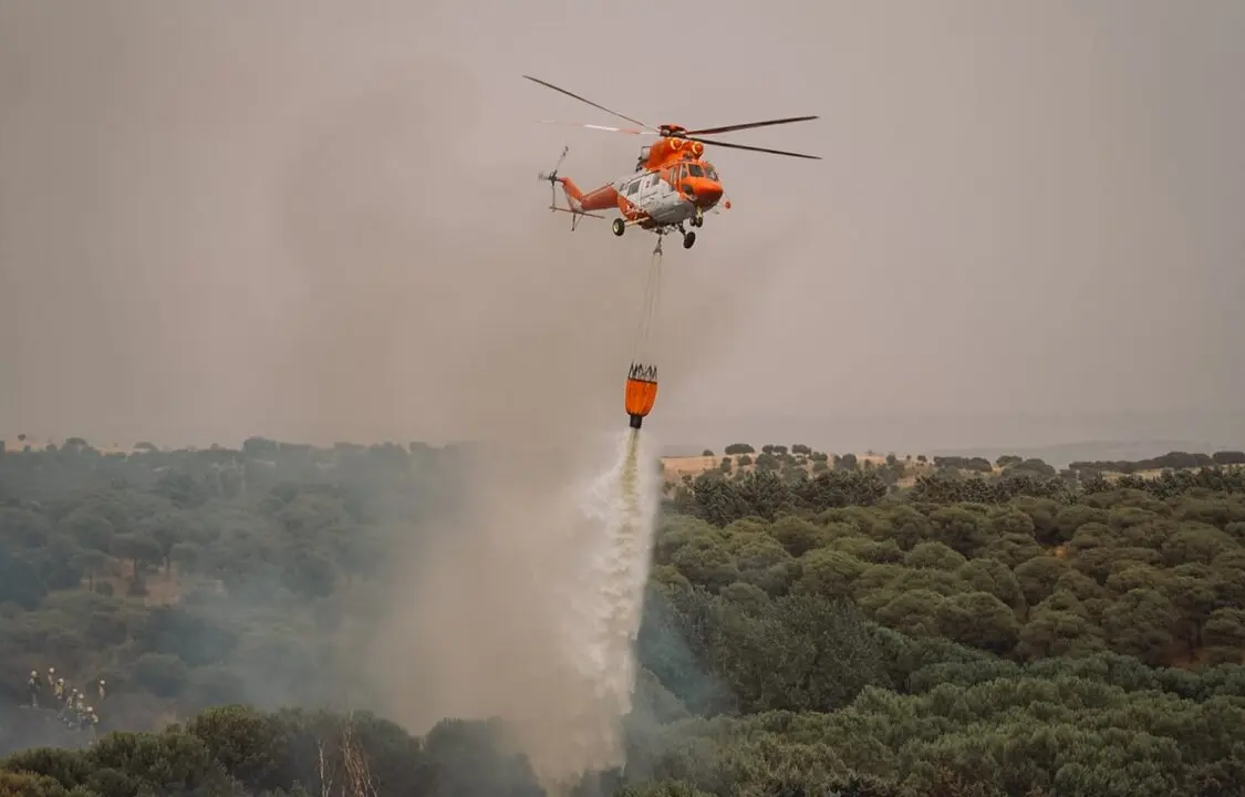 Un helic&oacute;ptero vierte agua en la zona del incendio declarado esta tarde entre Colmenar Viejo y Tres Cantos