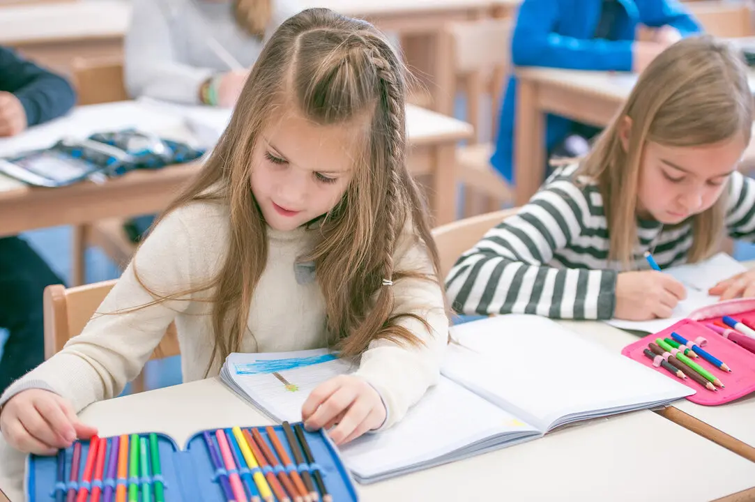 Two Girls Writting and Reading in the Primary School Class