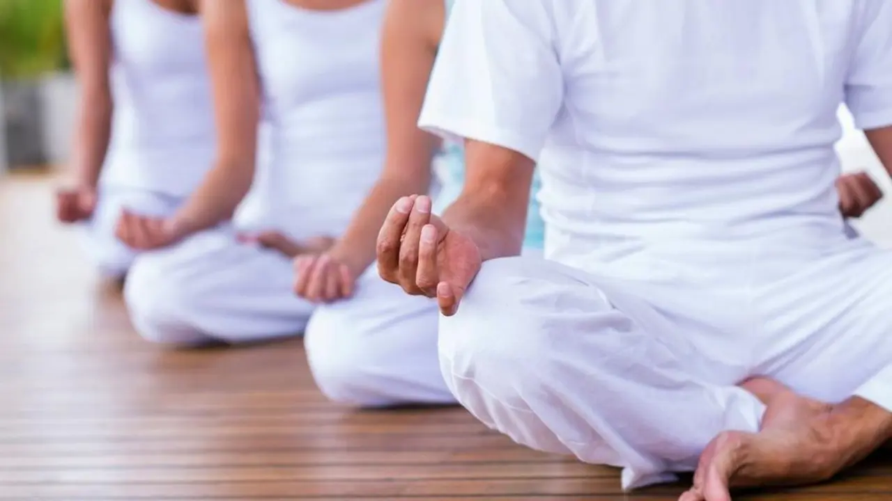 Tres personas comienzan una sesi&oacute;n de yoga y meditaci&oacute;n