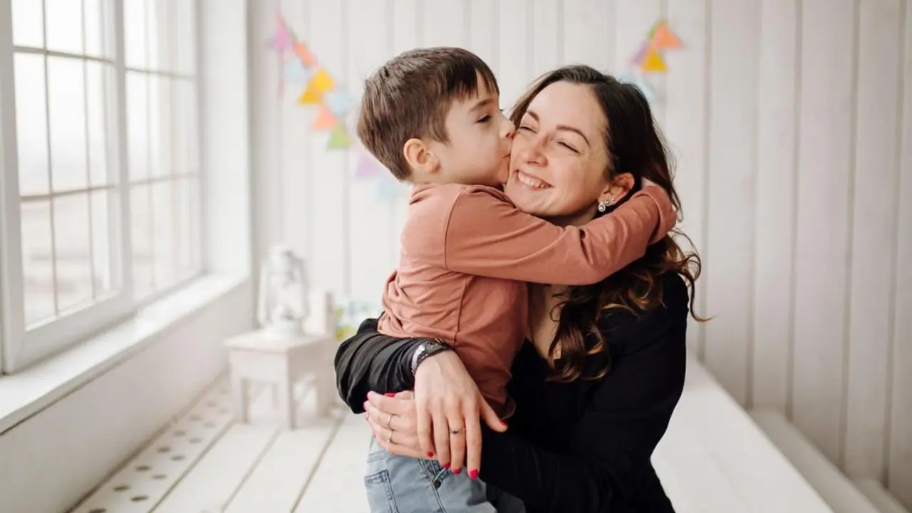 Mother and her son are posing in the studio and wearing casual clothes