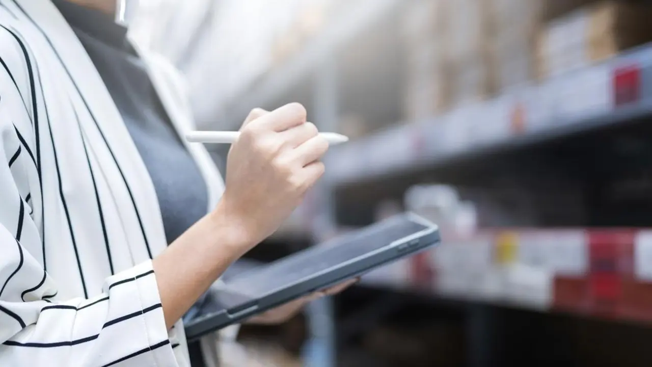 close up female business owner hand hold tablet device checking inventory stock at shop warehouse distributor factory business ideas concept