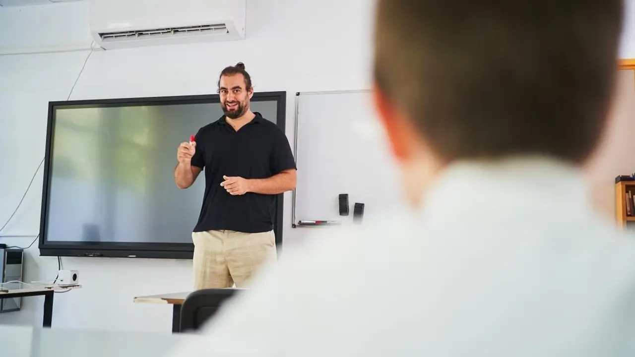 Un profesor da clase en un aula habilitado con un equipo de climatizaci&oacute;n