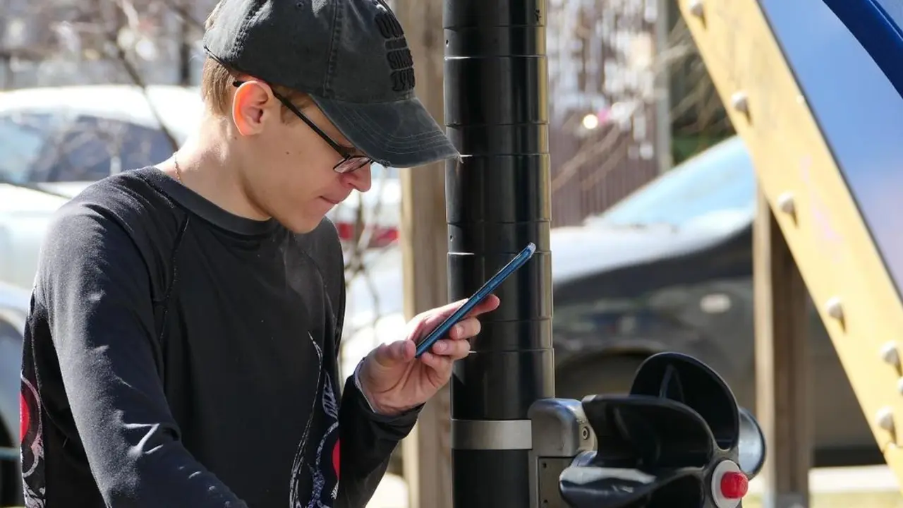Joven mira sus contenidos en redes sociales en un tel&eacute;fono m&oacute;vil