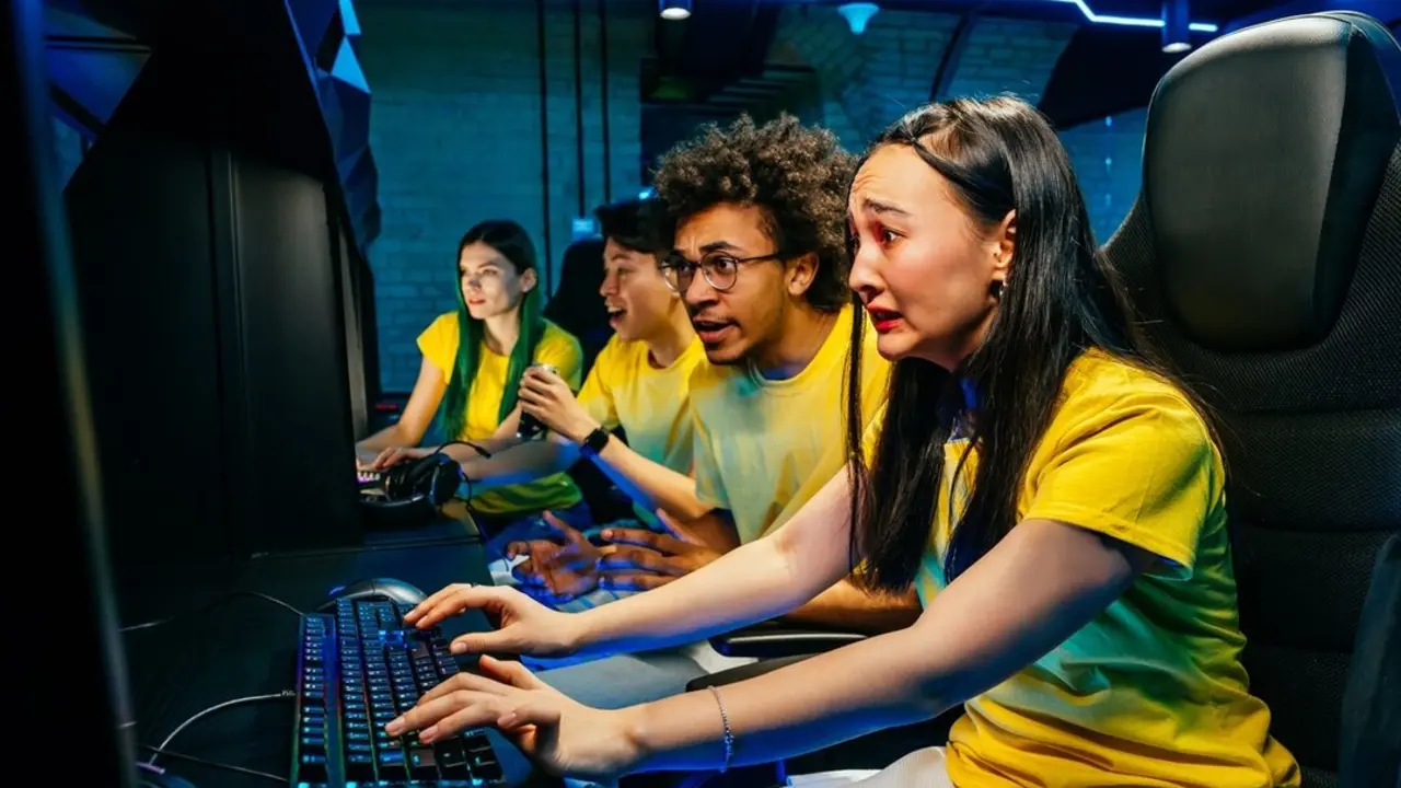 Multiethnic group of young friends playing videogames - Team of professional esport gamers playing in competitive video games on a cyber games tournament
