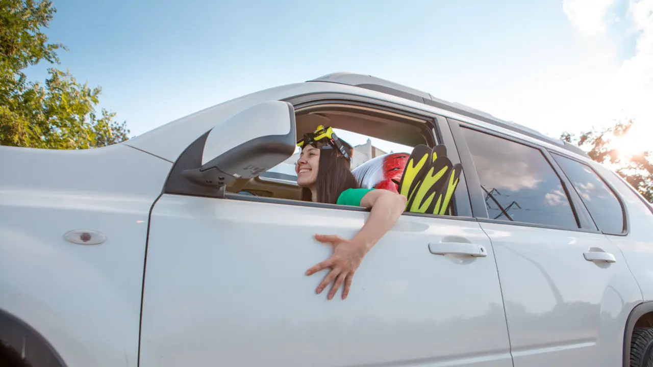 sea car travel trip smiling woman driver in car full of vacation stuff copy space