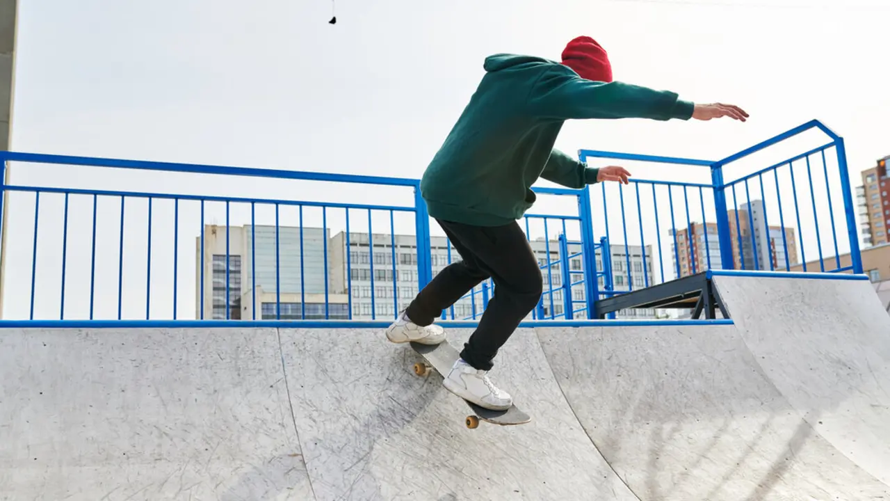 Full length portrait of unrecognizable young man doing skateboard stunts on ramp in extreme sports park, copy space