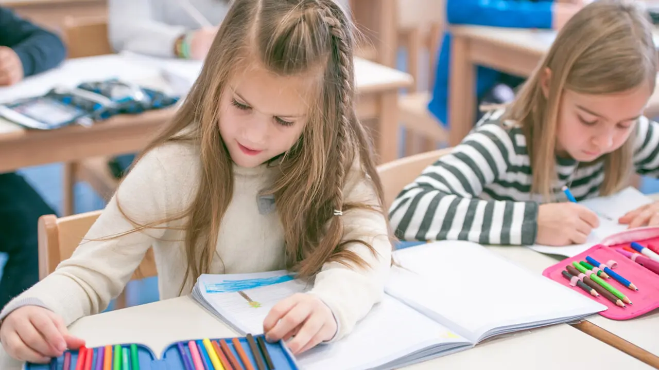 Two Girls Writting and Reading in the Primary School Class