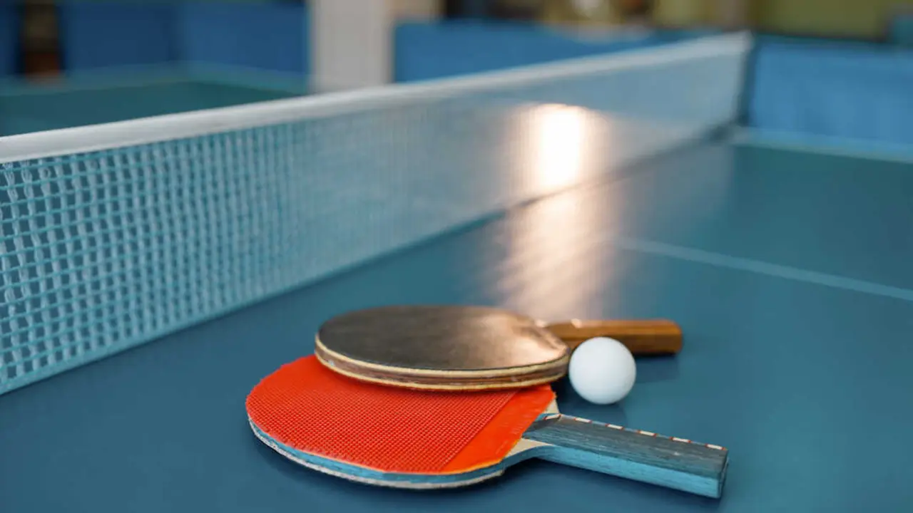 Two ping pong paddles on the table with net, nobody, closeup view. Table-tennis club, tennis concept