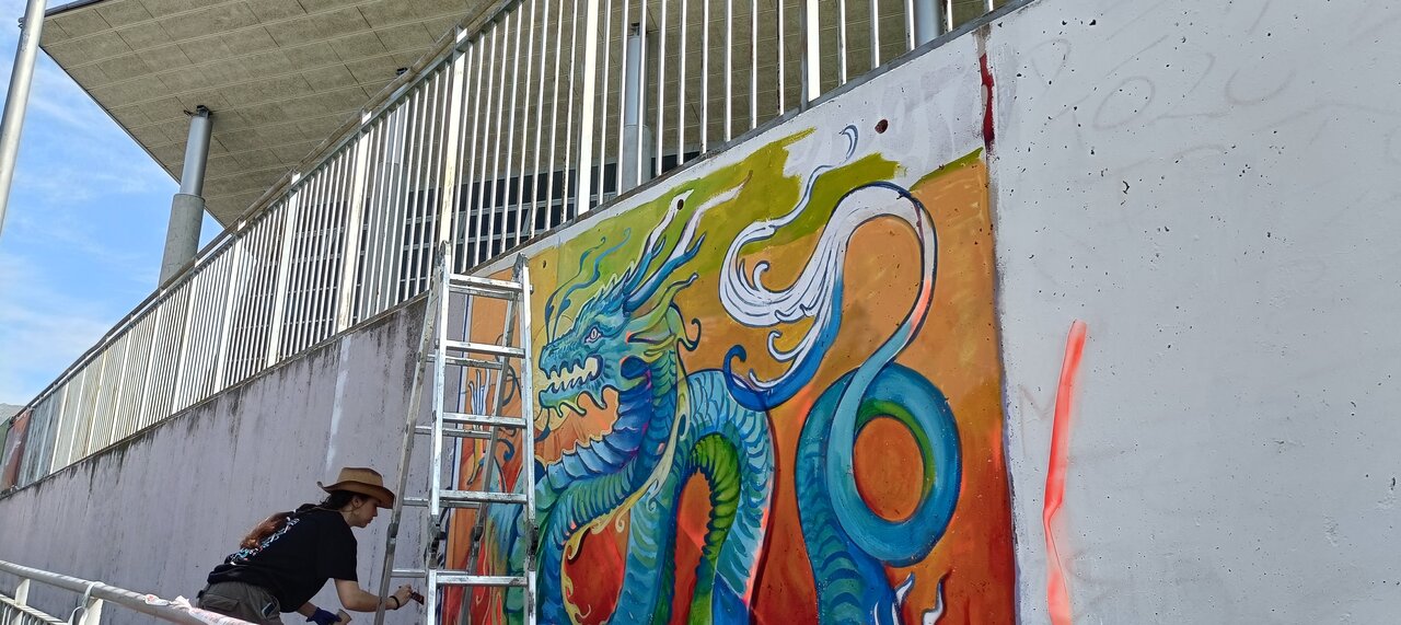 La artista Leyvel realizando su mural.