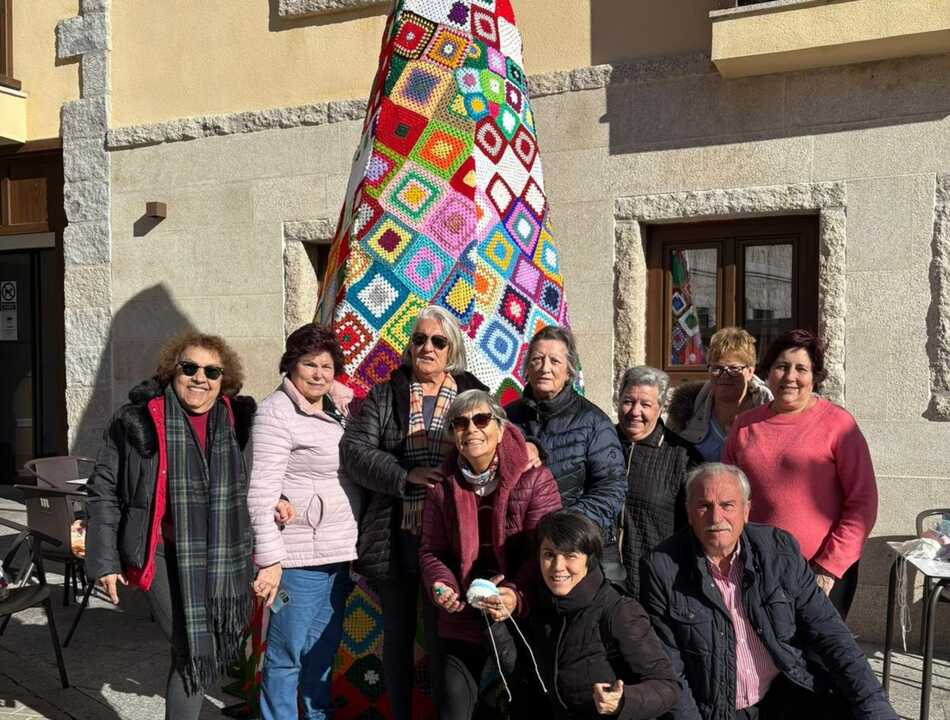 Varios de los participantes en la creación del Árbol de Navidad hecho de ganchillo de Manzanares El Real junto a la artesana Rosa Marcano (izquierda de la imagen)