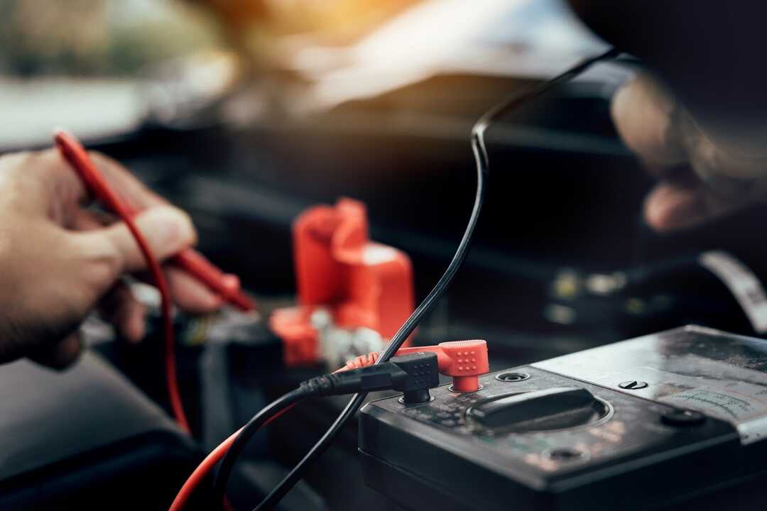 Mecánico de automóvil vigila nivel de batería de coche